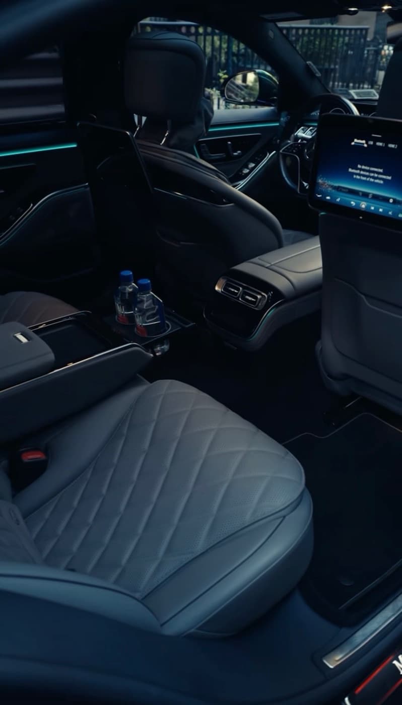 Rear cabin of a Mercedes-Benz S-Class with bottled water in the center console