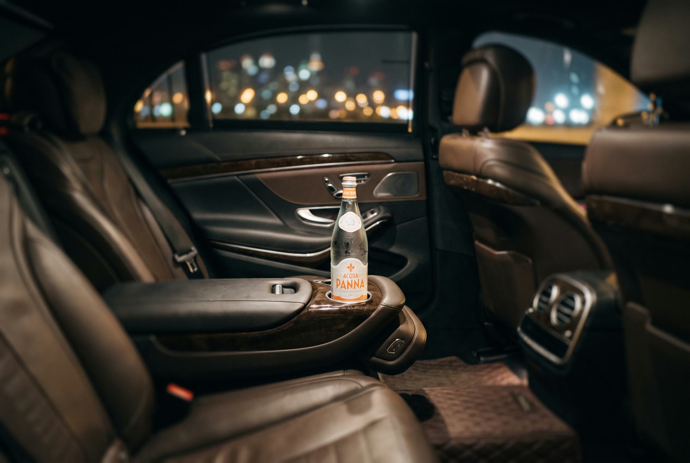 Mercedes-Benz S-Class executive rear cabin at night — quilted leather seats, footrest and 64-color ambient lighting